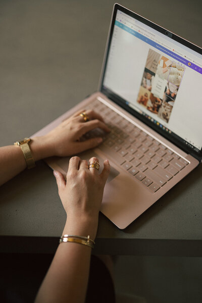 A photo of the owner typing on her laptop.