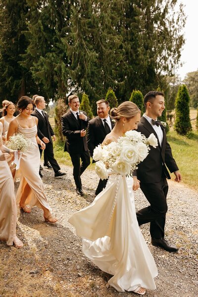 Bride and groom walking followed by their bridesmaids and groomsman