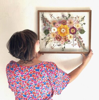 Nicole holds up a floating frame flower preservation.