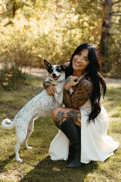 cute white and black dog with her owner hugging her