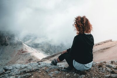 Person on a mountain pondering what makes complex trauma unique