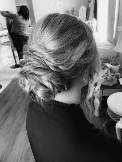 A curled bridal updo hairstyle in a bridal suite in black and white