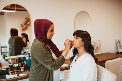 Maya working on a bride’s makeup in natural lighting