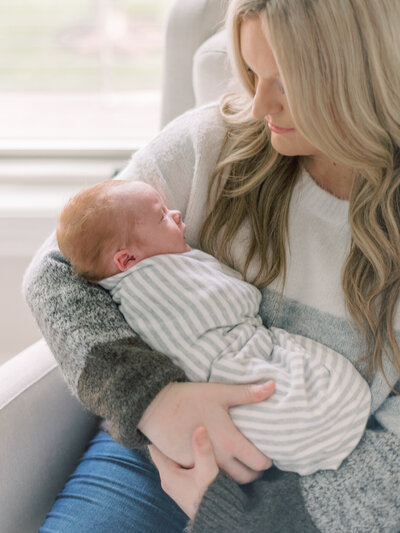 Mom holding her sweet newborn baby boy in Richmond VA nursery.