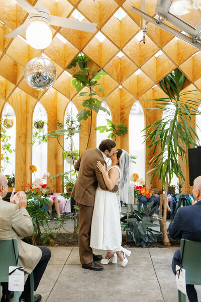 bride and groom kissing under a disco ball