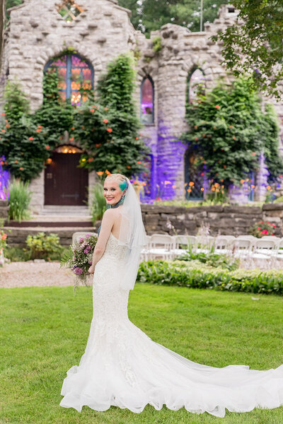 Bride in front of castle turning over her shoulder