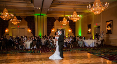 Bride and groom share first dance in crystal ballroom at the Ambassador Banquet & Conference Center