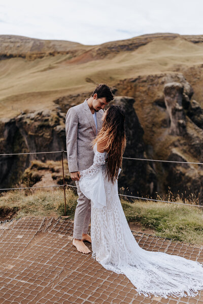 Iceland Wedding Photographer captures bride and groom looking at one another after mountain wedding