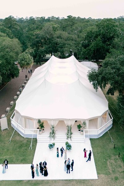 A newlywed couple walking between flowers in front of their Portofino wedding venue.