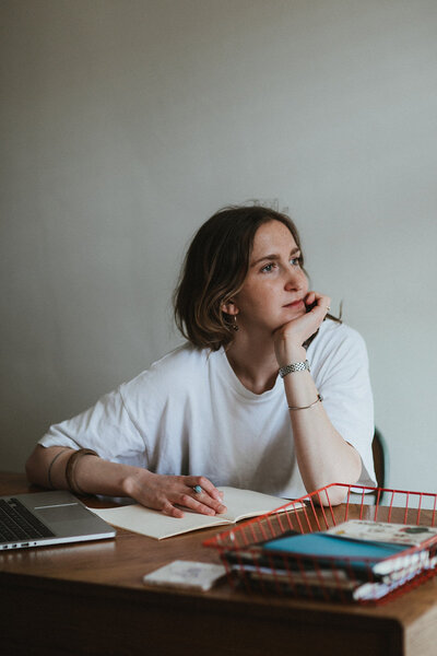 Copywriter in her home office in Oxfordshire looks out the window, taking a break from her work 