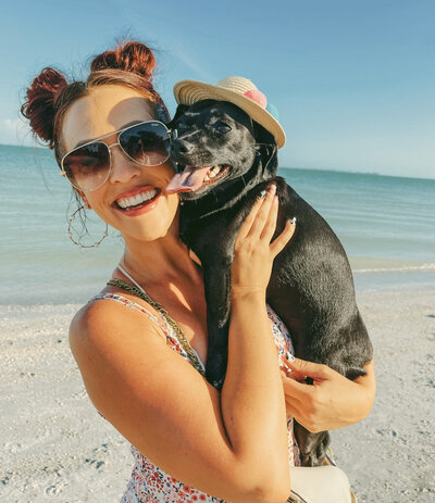 girl wearing sunglasses holding dog 