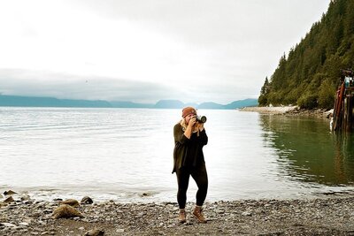 Woman sitting outside coffee shop holding camera