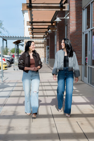 Stef and Tara walking on sidewalk and talking