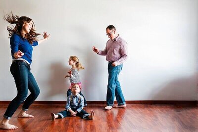 Gina and her family having fun dancing together in a bright room.