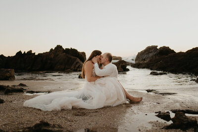 Romantic and intimate portrait of Bride and Groom kissing on the beach, captured by Kelsey Vera Photography, intimate and romantic wedding photographer in Airdrie, Alberta. Featured on the Bronte Bride Vendor Guide.