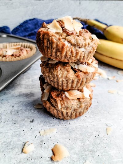 coconut chocolate chunk banana muffins stacked in a stack of 3 aesthetically