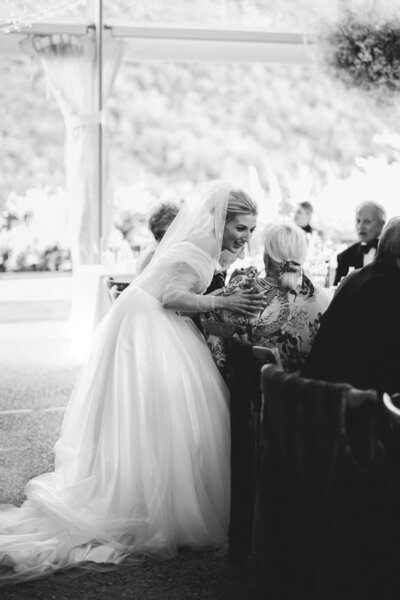 black and white candid moment between stunning bride and a guest at the reception