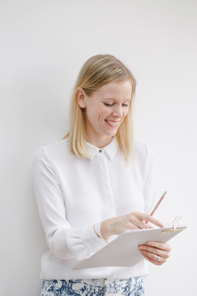 Image of Philippa holding a clipboard ready to answer your FAQs