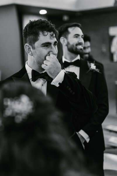 Black and white image of emotional groom during wedding ceremony