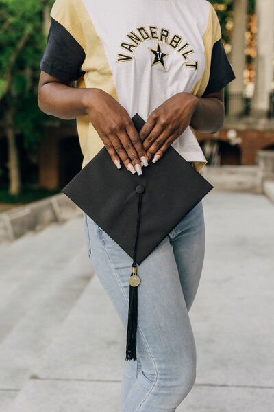 Vanderbilt grad holding her cap and wearing a Vanderbilt t-shirt