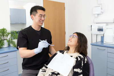 Happy dentist and patient in dental chair