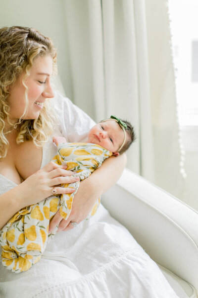 Mother holding newborn baby wrapped in swaddle Green Bay