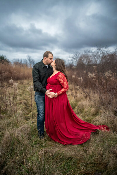 maternity portraits in field  winter time with clouds