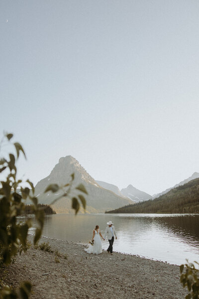 bride and groom walking together in front of mountains in montana during their elopement