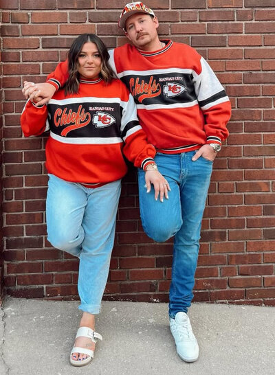 Husband and wife (owners) in photo wearing Chiefs gear