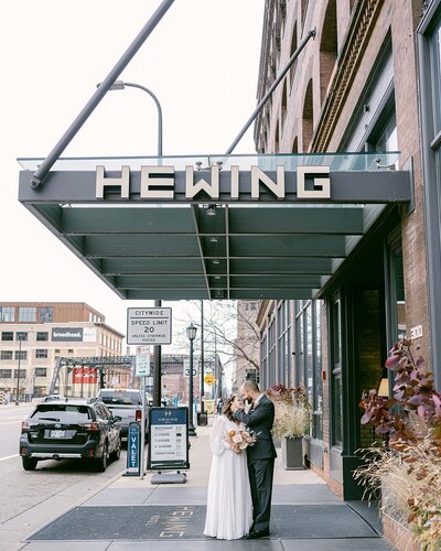 A couple nearly kiss under the awning of the Hewing Hotel before their Minneapolis, Minnesota wedding.