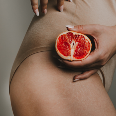 Woman with orange on her skin, highlighting skin improvement and natural beauty care, crafted by Muse Studio for a holistic wellness and beauty campaign.