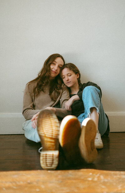 couple snuggled together sitting on the ground