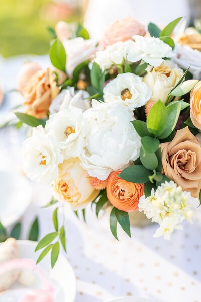 Peach, orange, white, and green peony and rose bouquet centerpiece.