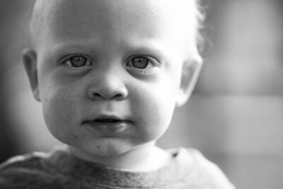 black and white toddler portrait with dirt on face looks like film