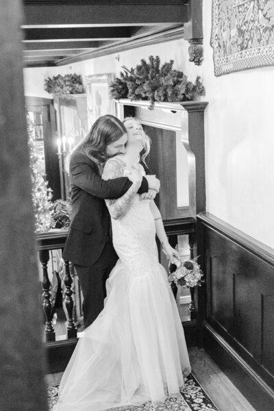 A bride and a groom canoodle on the grand staircase for Gramercy Mansion Wedding Photographer