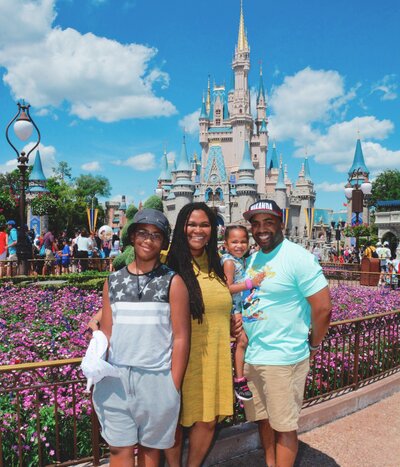 Family posing in front of Cinderella’s Castle at Disney.