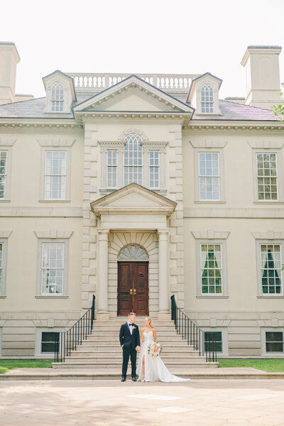 Bride and groom standing in front of Great Marsh Estate.