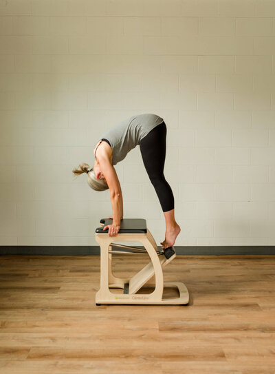 Woman practicing Upside Down Push Up on Low Chair