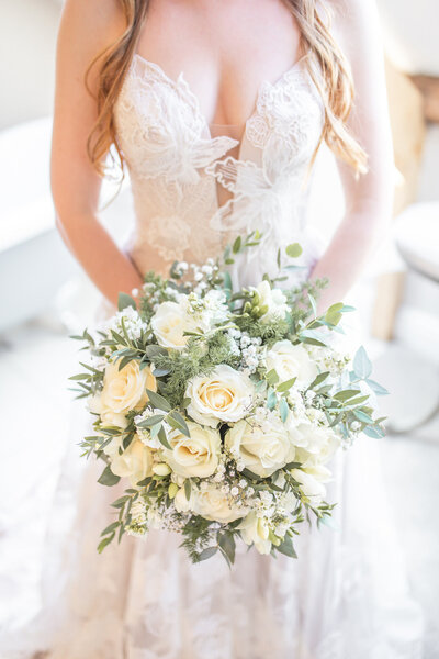 Cheshire bride wearing a lace wedding dress holding a rose bouquet