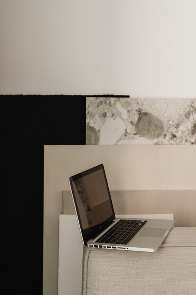 Open laptop on a minimalist desk with neutral tones and abstract art in the background, embodying the aesthetic often explored in our photography mentoring program.