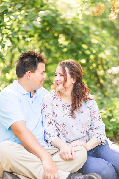 Engaged couple holding hands and laughing in black and white