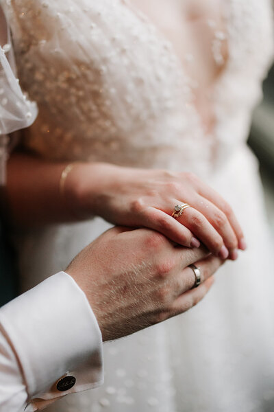 Handen van bruid en bruidegom met hun trouwringen, vastgelegd tijdens hun bruiloft, georganiseerd door een weddingplanner en ceremoniemeester