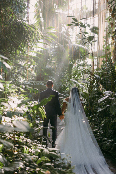 Bride and groom walking through the Atlanta botanical gardens