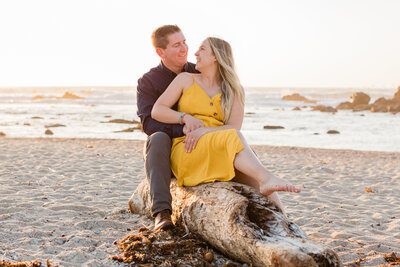 Sitting on a log at the beach during engagement photography session