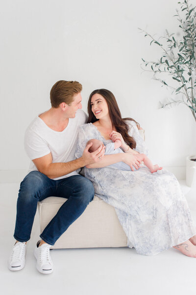 Beautiful new parents hold their newborn during their Orlando Studio newborn session with the owner and photographer of M. Lauren Photography