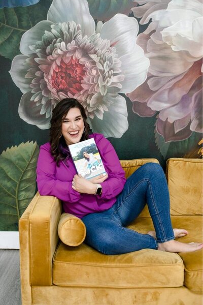 Melyssa on a sofa with a book, ideal for personal branding photoshoots and content on reading, relaxation, and cozy home settings.