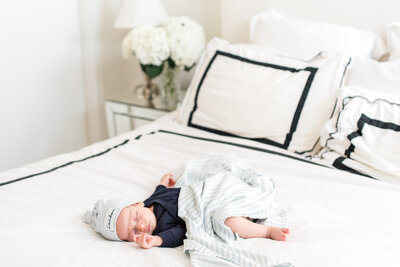 Baby wrapped in blanket lying on a bed