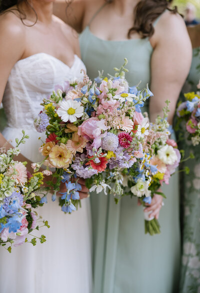 Bridesmaids holding a colorful bridal bouquet of wildflowers at the Inn at Barley Sheaf Farm in Pennsylvania