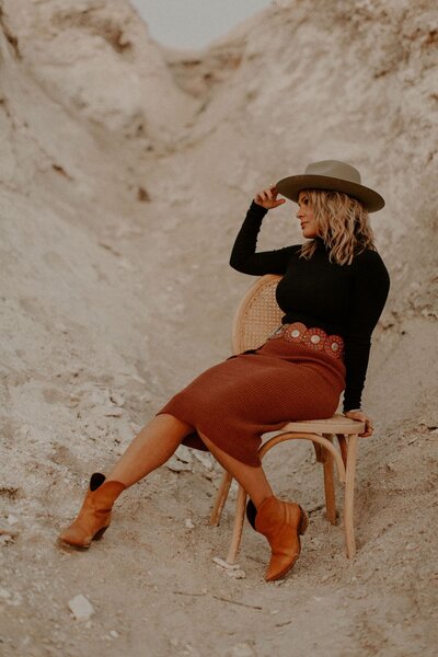 Emily from Tousled Beauty Co sitting in the sand.