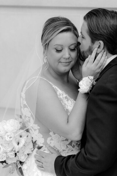 a black and white image of a bride and groom embracing